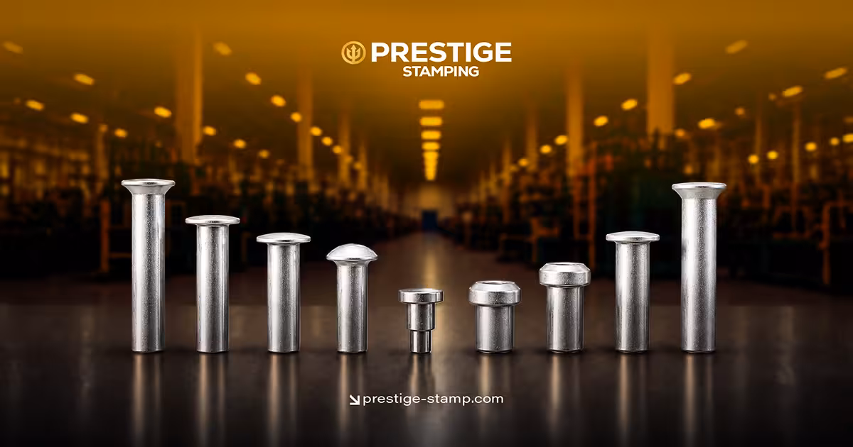 Eight metal fasteners of varying shapes and sizes are lined up in front of a blurred factory background, with “Prestige Stamping” and website shown above.