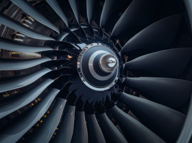 Close-up view of the interior of a jet engine, showing the central hub and multiple fan blades arranged in a circular pattern.