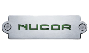 A metallic nameplate with the word "NUCOR" cut out in green block letters.